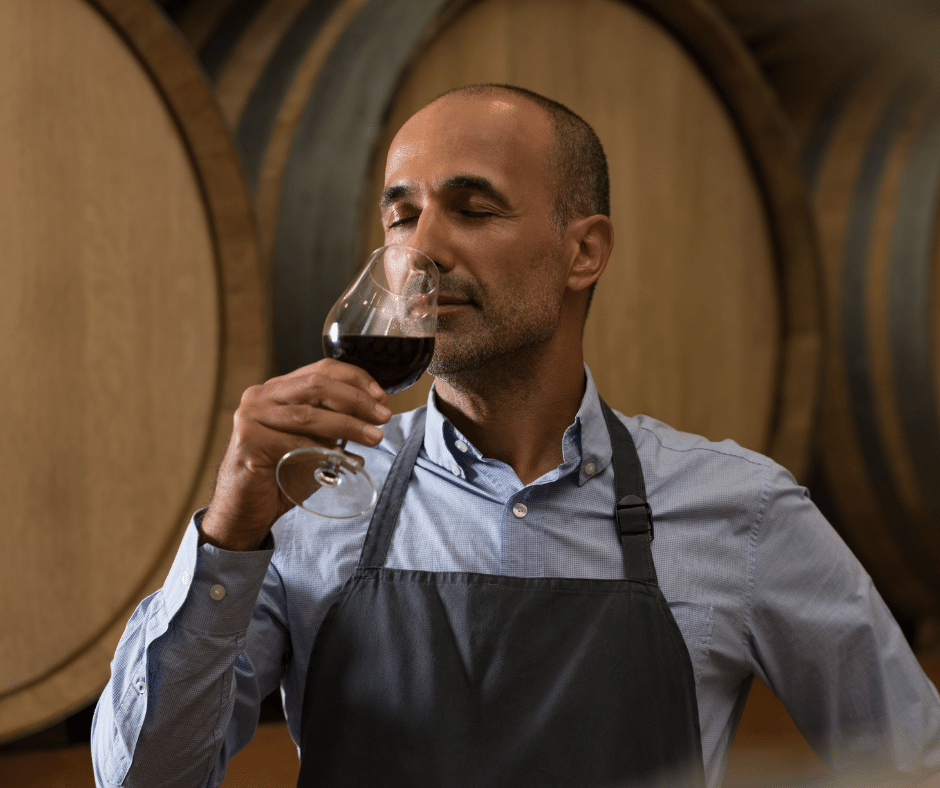 a guy smelling a glass of wine